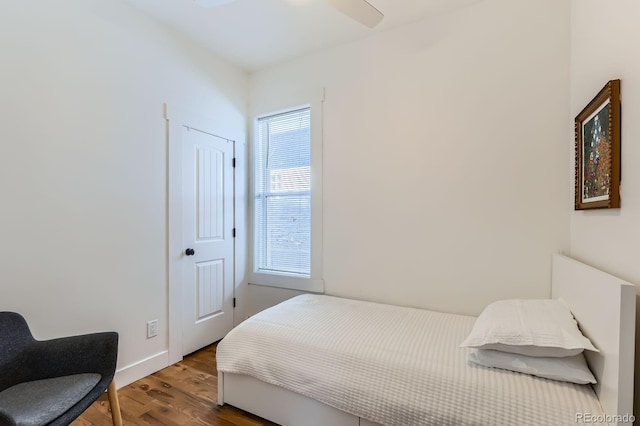 bedroom featuring baseboards and wood finished floors