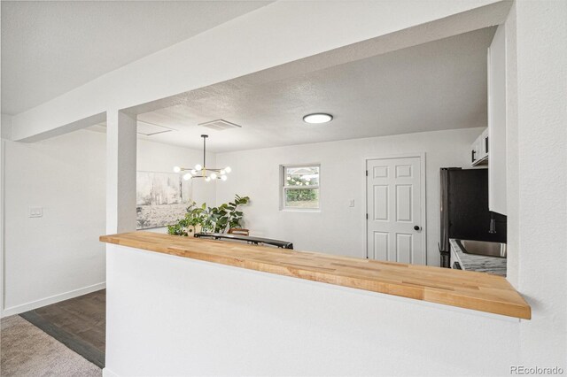 1330 Oak Pl, Thornton, CO 80229 - kitchen featuring wooden counters, a chandelier, freestanding refrigerator, dark wood finished floors, and baseboards
