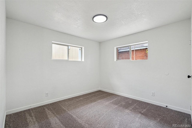 1330 Oak Pl, Thornton, CO 80229 - unfurnished room with healthy amount of natural light, dark colored carpet, baseboards, and a textured ceiling