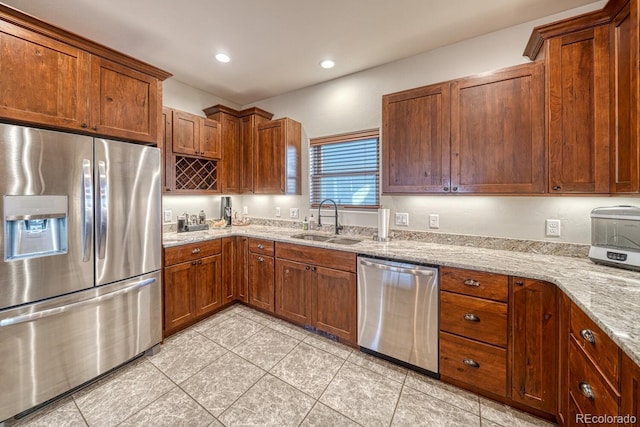 kitchen featuring light stone counters, sink, light tile patterned floors, and appliances with stainless steel finishes