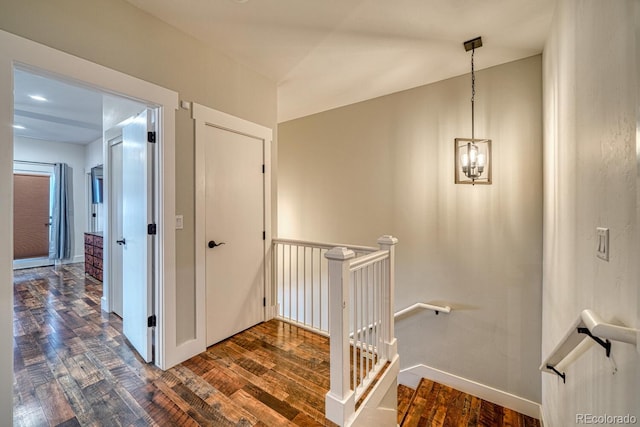 hallway featuring a notable chandelier and dark wood-type flooring