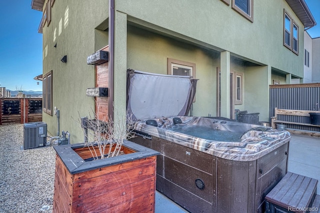 view of patio / terrace featuring cooling unit and a hot tub