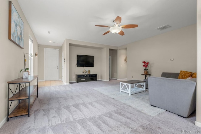 carpeted living area featuring ceiling fan and baseboards