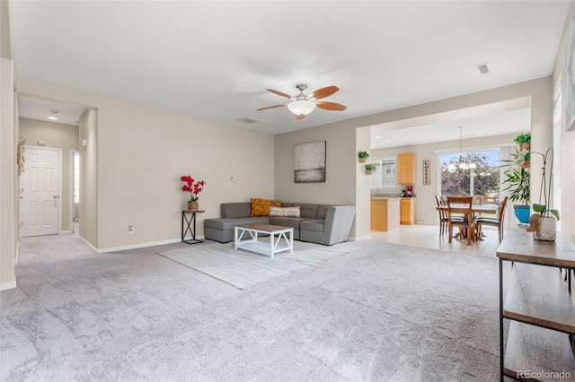 living area with ceiling fan and light colored carpet