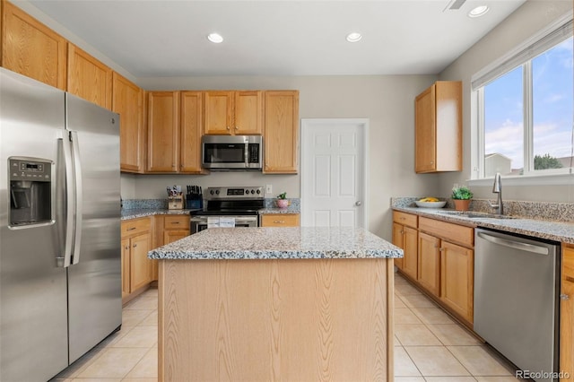kitchen featuring appliances with stainless steel finishes, a center island, light tile patterned floors, light stone counters, and recessed lighting