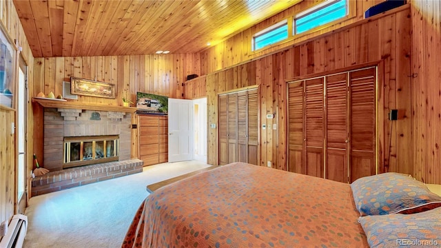 2602 Hidden Valley Rd, Sedalia, CO 80135 - bedroom featuring baseboard heating, wood walls, carpet flooring, a brick fireplace, and wood ceiling