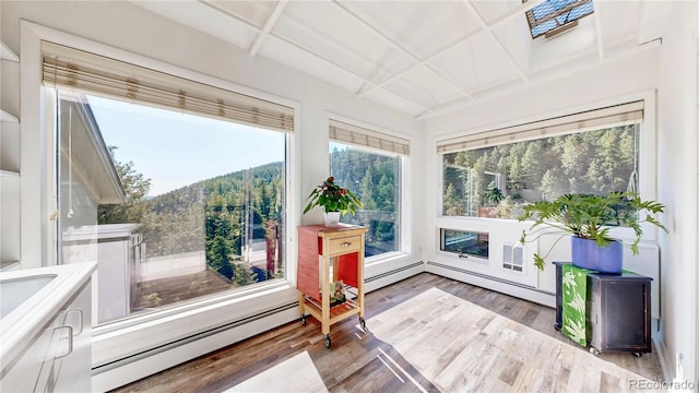 2602 Hidden Valley Rd, Sedalia, CO 80135 - sunroom / solarium featuring a baseboard heating unit, wood finished floors, and coffered ceiling