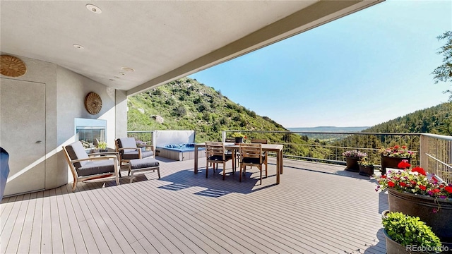 2602 Hidden Valley Rd, Sedalia, CO 80135 - deck featuring a mountain view, outdoor dining area, and a wooded view