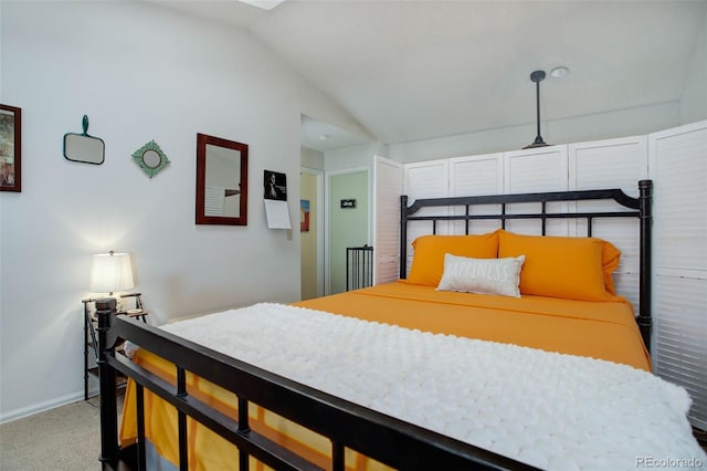 carpeted bedroom with lofted ceiling