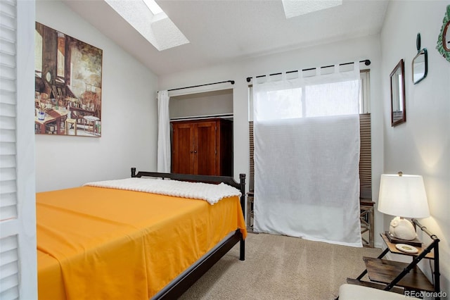 carpeted bedroom featuring lofted ceiling with skylight