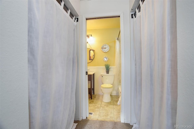 bathroom with tile patterned flooring, vanity, and toilet