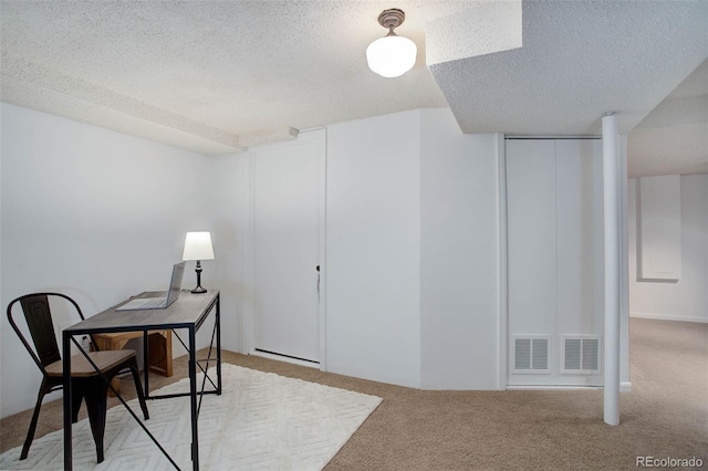 office space featuring light colored carpet and a textured ceiling