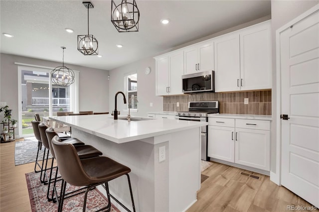 9836 Banner Peak St, Littleton, CO 80125 - kitchen with stainless steel appliances, a sink, a chandelier, light wood-type flooring, and recessed lighting