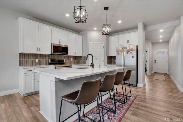 9836 Banner Peak St, Littleton, CO 80125 - kitchen with stainless steel appliances, light wood-style floors, tasteful backsplash, baseboards, and recessed lighting