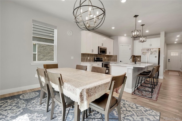 9836 Banner Peak St, Littleton, CO 80125 - dining area with a chandelier, light wood-type flooring, recessed lighting, and baseboards