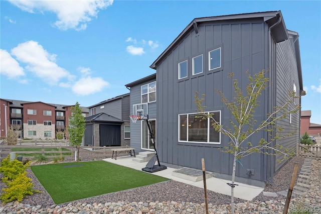 9836 Banner Peak St, Littleton, CO 80125 - rear view of property with board and batten siding, a lawn, and a patio area