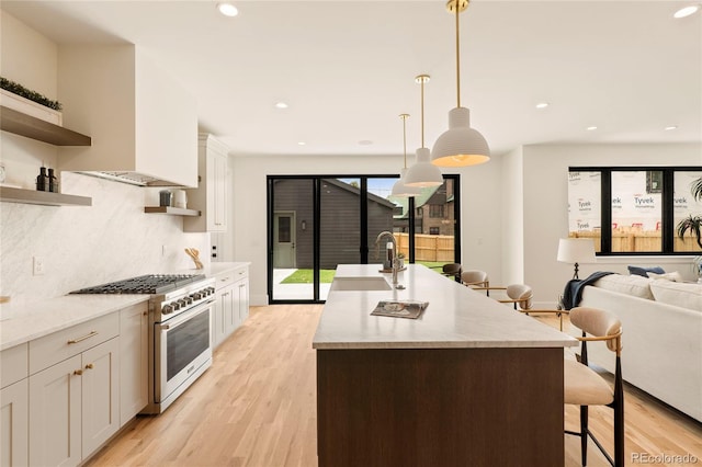2610 N Monroe St, Denver, CO 80205 - kitchen with stainless steel range, open shelves, light wood finished floors, a breakfast bar area, and backsplash
