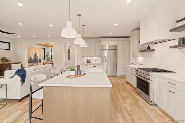 2610 N Monroe St, Denver, CO 80205 - kitchen with premium appliances, open shelves, light countertops, light wood-style flooring, and tasteful backsplash