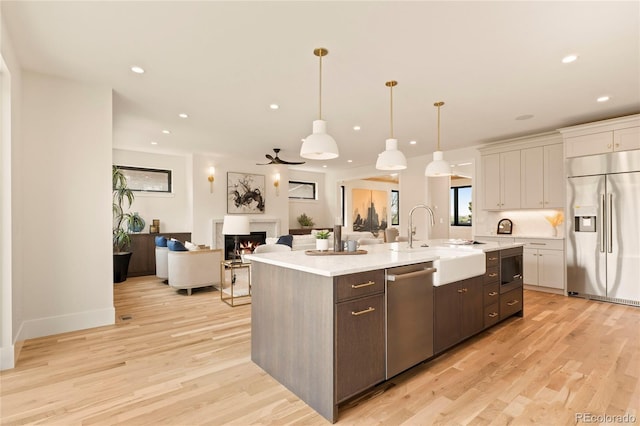 2610 N Monroe St, Denver, CO 80205 - kitchen featuring built in appliances, a sink, light countertops, light wood-style floors, and recessed lighting