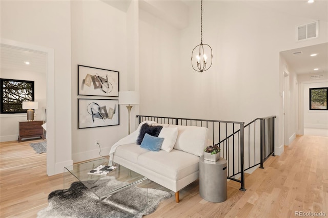 2610 N Monroe St, Denver, CO 80205 - living area featuring a chandelier, wood finished floors, a high ceiling, baseboards, and recessed lighting