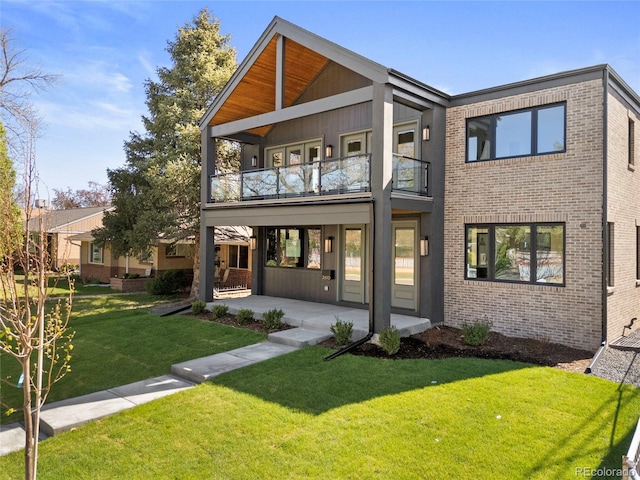 2610 N Monroe St, Denver, CO 80205 - back of house featuring a balcony, brick siding, a lawn, and a patio