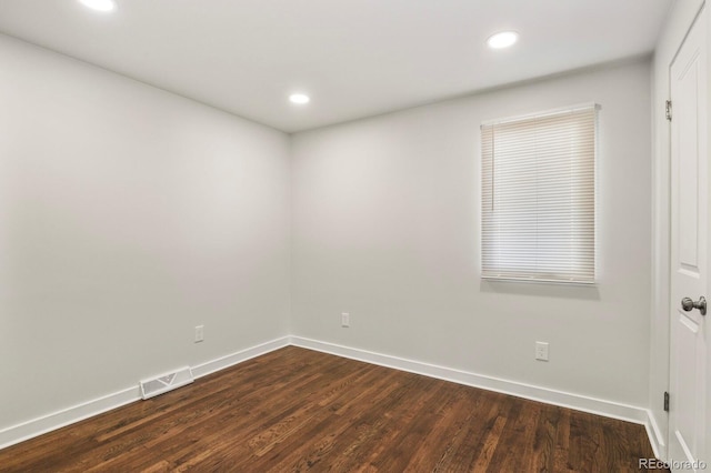 unfurnished room with dark wood-style floors, baseboards, visible vents, and recessed lighting