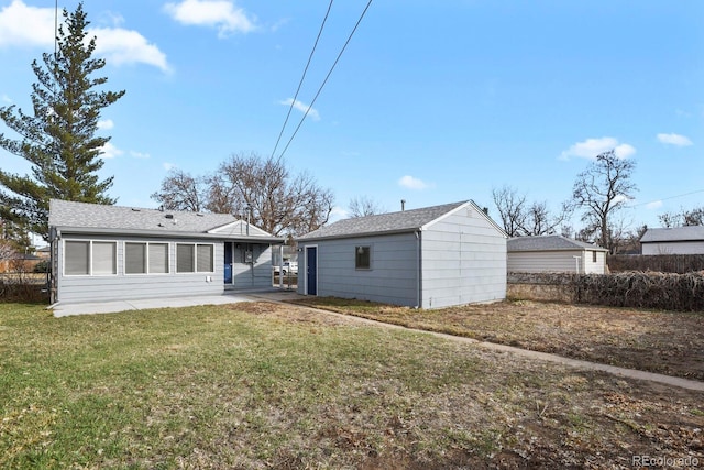 back of property with a patio, a lawn, and an outdoor structure