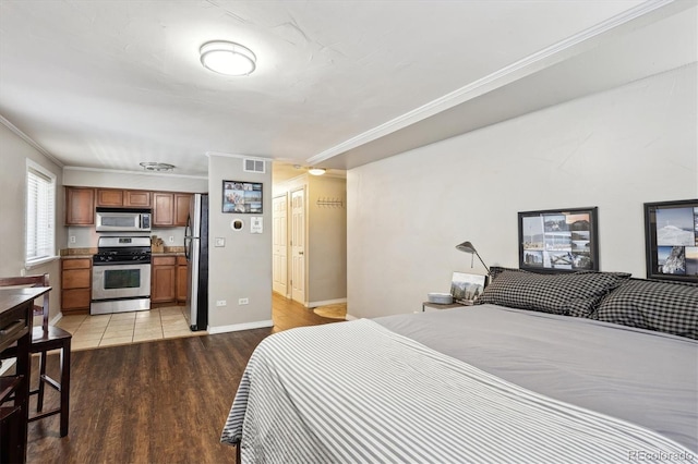 bedroom featuring crown molding, hardwood / wood-style flooring, and stainless steel fridge