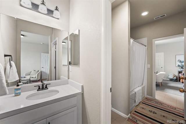 bathroom featuring tile patterned flooring, shower / bath combination with curtain, visible vents, and vanity