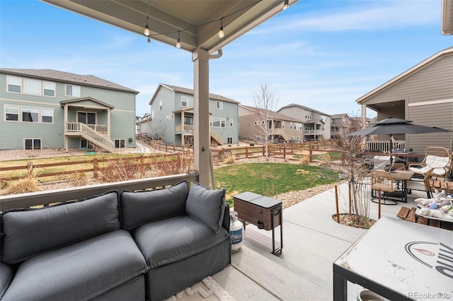 view of patio / terrace featuring an outdoor hangout area, fence, and a residential view