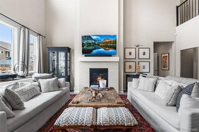 living area featuring a high ceiling and a tiled fireplace