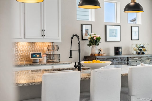 bar featuring decorative light fixtures and backsplash