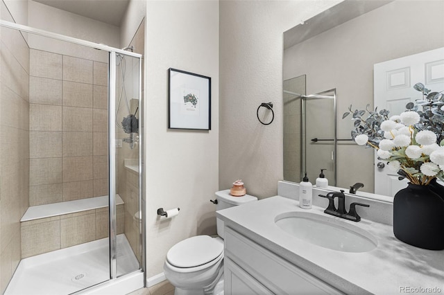 bathroom featuring vanity, toilet, and a stall shower