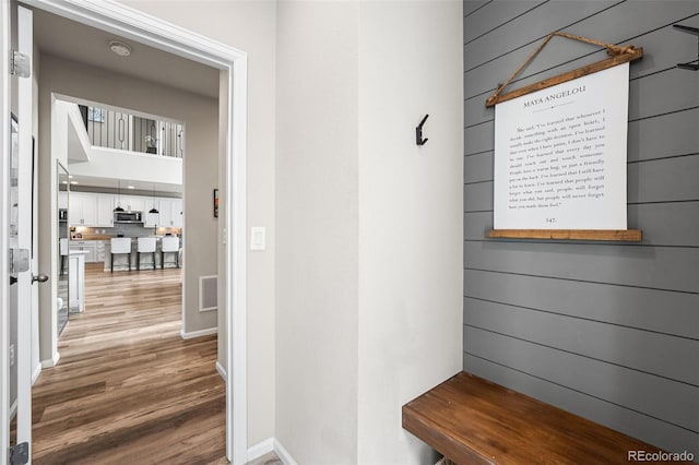 mudroom with baseboards, visible vents, and wood finished floors