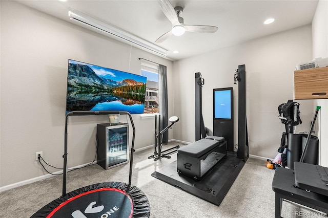 exercise area with a ceiling fan, baseboards, and carpet
