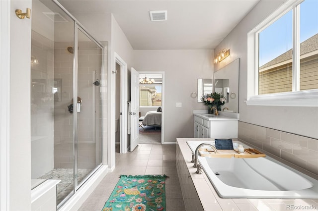 ensuite bathroom featuring a stall shower, connected bathroom, plenty of natural light, and visible vents
