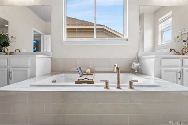 full bathroom with vanity and a bath