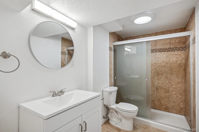 bathroom with tile patterned floors, walk in shower, toilet, vanity, and a textured ceiling