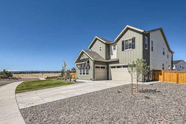 view of front of property featuring board and batten siding, fence, driveway, and an attached garage