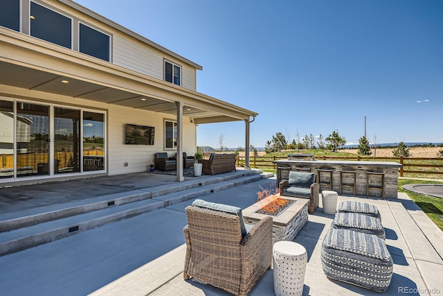 view of patio / terrace featuring an outdoor living space with a fire pit and exterior kitchen