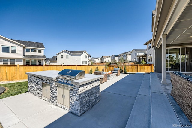 view of patio with a residential view, an outdoor kitchen, and a fenced backyard