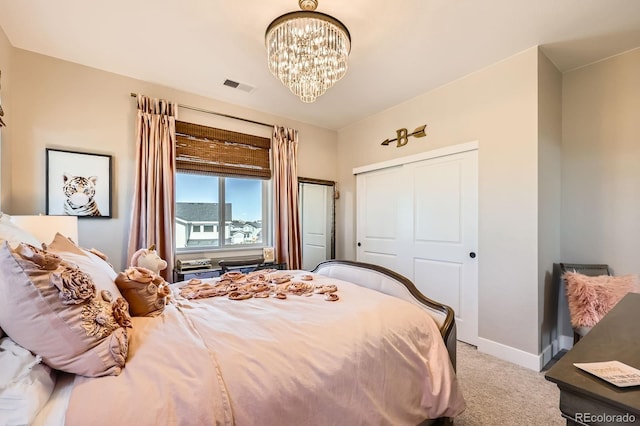 carpeted bedroom featuring a chandelier, baseboards, and a closet