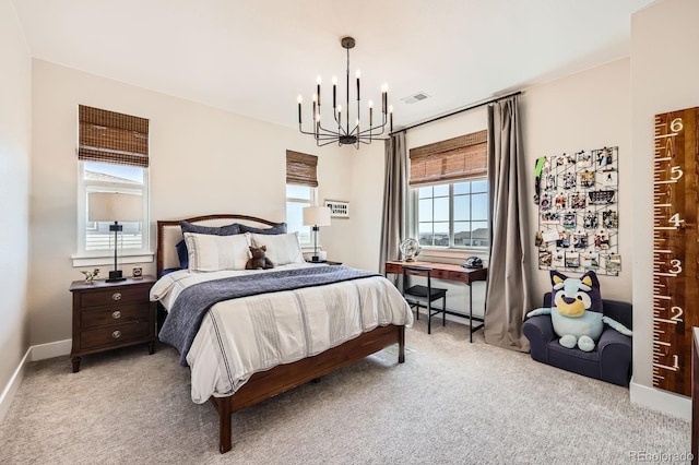 carpeted bedroom with a chandelier and baseboards