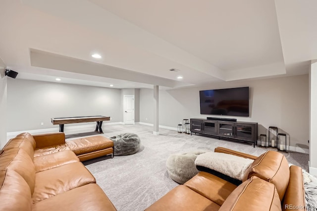 carpeted living area featuring baseboards, a raised ceiling, and recessed lighting