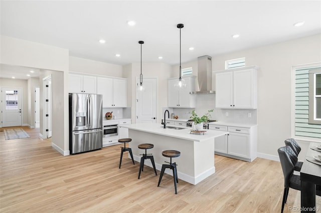 5970 S Platte Canyon Dr, Littleton, CO 80123 - kitchen with appliances with stainless steel finishes, ventilation hood, a sink, a kitchen bar, and tasteful backsplash