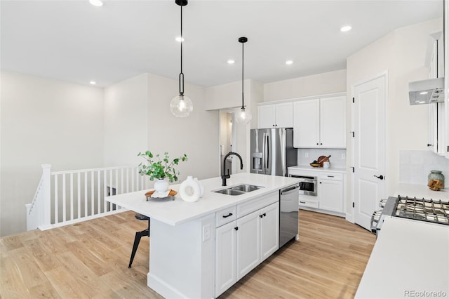 5970 S Platte Canyon Dr, Littleton, CO 80123 - kitchen featuring appliances with stainless steel finishes, a sink, light wood finished floors, light countertops, and recessed lighting