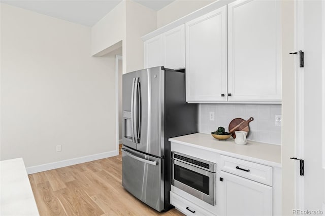 5970 S Platte Canyon Dr, Littleton, CO 80123 - kitchen featuring stainless steel fridge with ice dispenser, white cabinetry, light wood-type flooring, light countertops, and backsplash