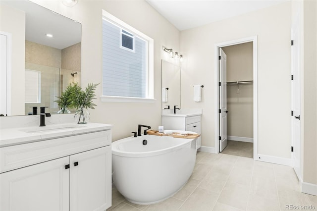 5970 S Platte Canyon Dr, Littleton, CO 80123 - full bathroom featuring two vanities, a soaking tub, a tile shower, and baseboards
