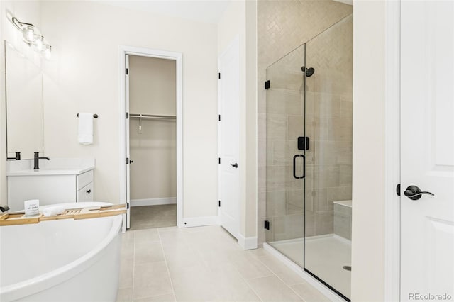 5970 S Platte Canyon Dr, Littleton, CO 80123 - full bath featuring a shower stall, vanity, a freestanding tub, a spacious closet, and tile patterned floors