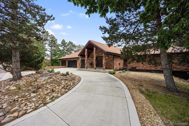 12570 W 60th Ave, Arvada, CO 80004 - view of front of property with concrete driveway, an attached garage, a tiled roof, and brick siding